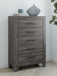 Sylveri Warm Gray Five Drawer Chest in a bedroom