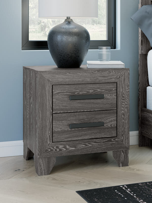 Sylveri Warm Gray Two Drawer Nightstand beside a bed