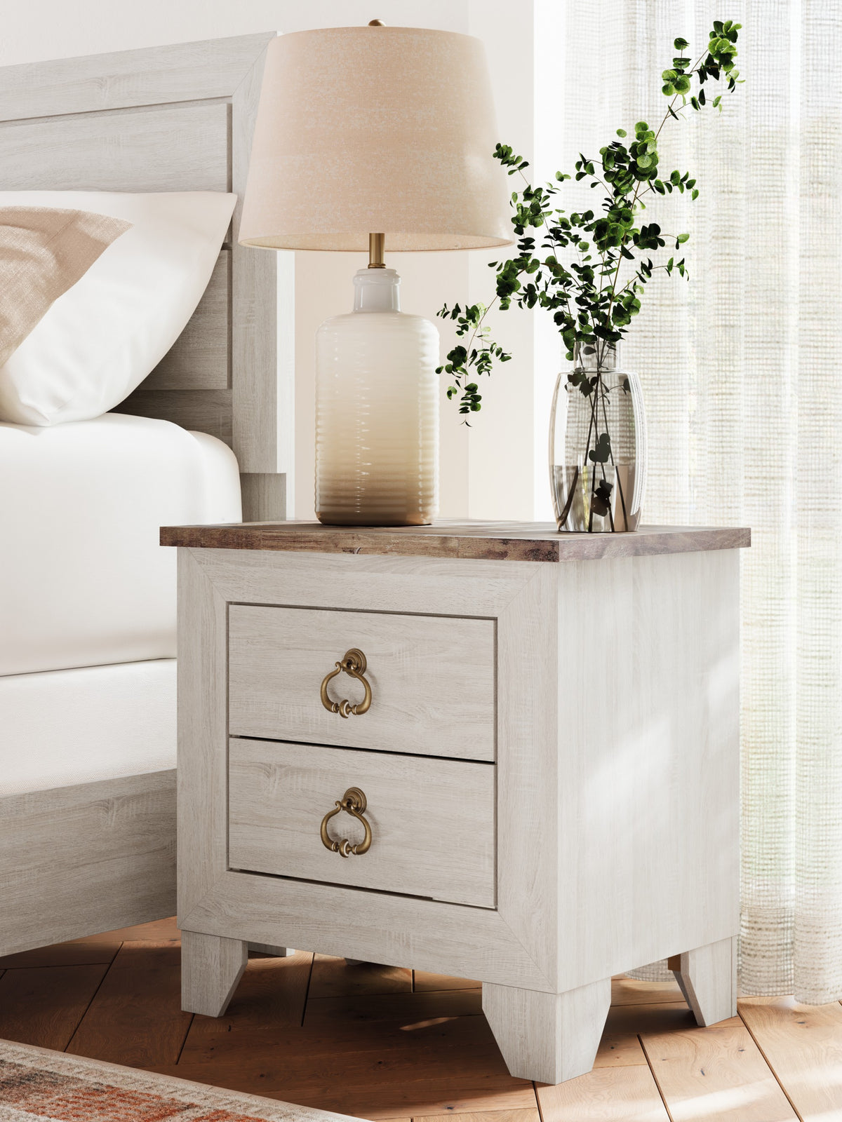 Laigmeyer Two-tone Two Drawer Nightstand beside a bed